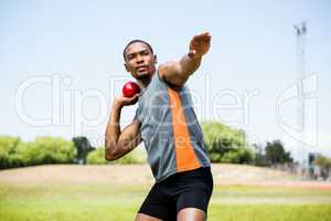 Male athlete about to throw shot put ball