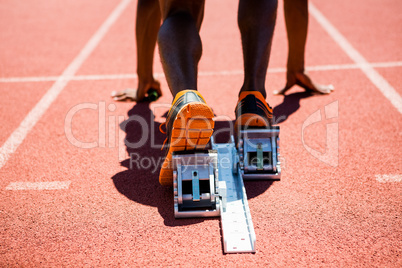 Feet of an athlete on a starting block about to run