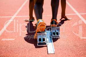 Feet of an athlete on a starting block about to run
