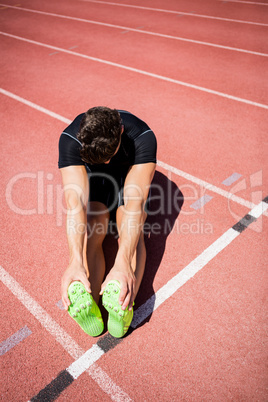 Tired athlete sitting on the running track