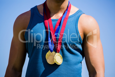 Athlete posing with gold medals around his neck