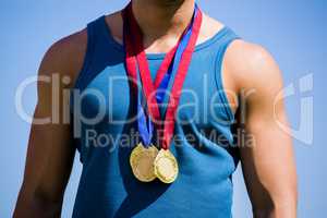 Athlete posing with gold medals around his neck