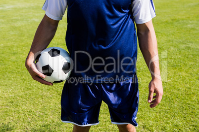 Soccer player standing with a ball