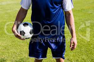 Soccer player standing with a ball