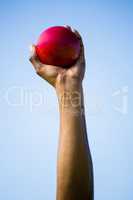 Athletes hand holding shot put ball