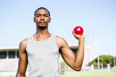Male athlete holding shot put ball