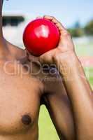 Male athlete holding shot put ball