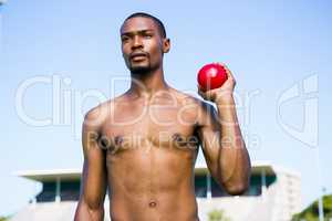 Male athlete holding shot put ball