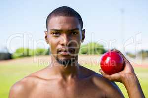 Male athlete holding shot put ball