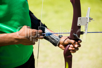 Mid section of athlete practicing archery