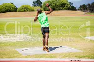 Male athlete preparing to throw shot put ball