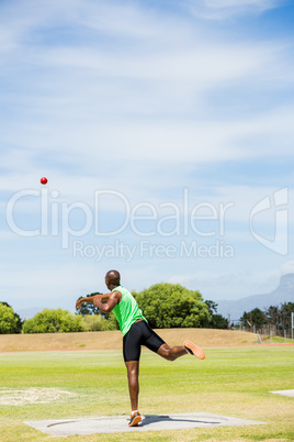 Male athlete throwing shot put ball