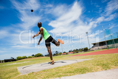 Male athlete throwing shot put ball