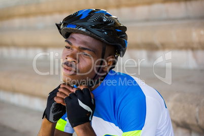 Athlete putting on cycling helmet