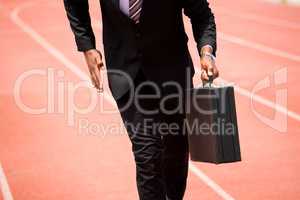 Mid section of businessman running on a running track