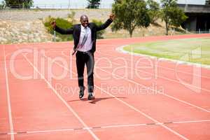 Excited businessman standing on the running track
