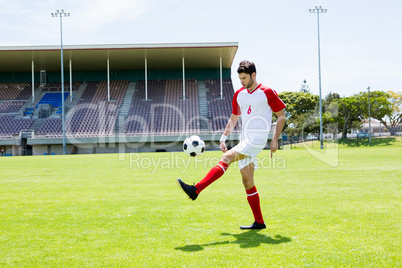 Football player juggling the football with his feet