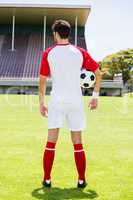 Rear view of a football player with a ball