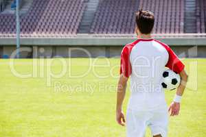 Rear view of a football player with a ball