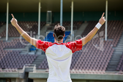 Excited football player standing in stadium