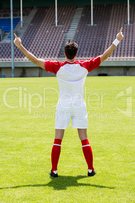 Excited football player standing in stadium