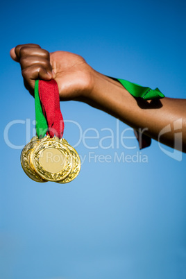 Athlete hand showing his gold medals