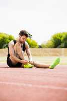Athlete tying his shoe laces on running track