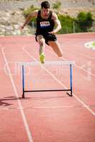 Athlete jumping above the hurdle