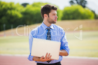 Businessman using a laptop on the running track