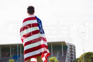 Athlete with american flag wrapped around his body