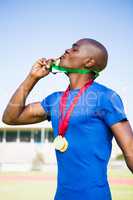 Athlete kissing his gold medals