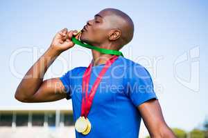 Athlete kissing his gold medals