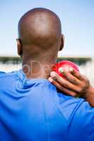 Male athlete preparing to throw shot put ball