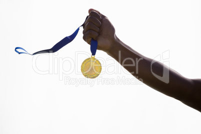 Hand of athlete holding gold medal