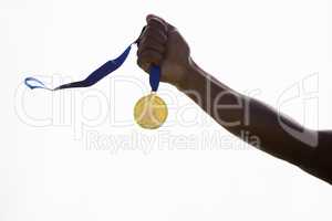 Hand of athlete holding gold medal