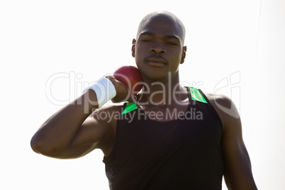 Male athlete preparing to throw shot put ball