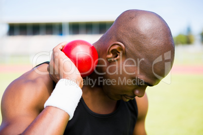 Male athlete holding shot put ball