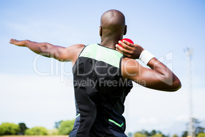 Male athlete preparing to throw shot put ball