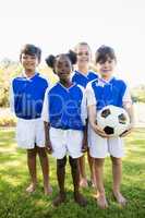 Portrait of children soccer team standing bare feet