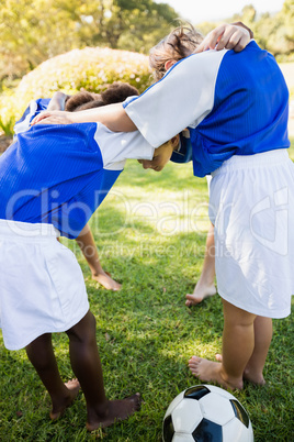 Facing view of soccer team forming huddle