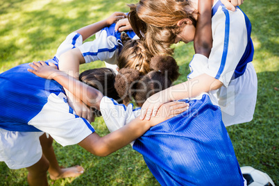 Overhead view of soccer team forming huddle