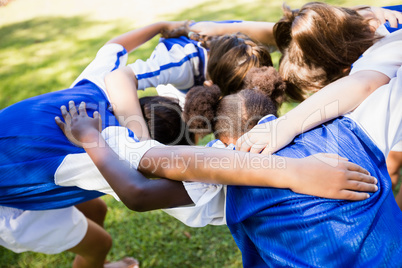 Overhead view of soccer team forming huddle