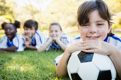 Close up view of girl lying on the floor with her soccer team