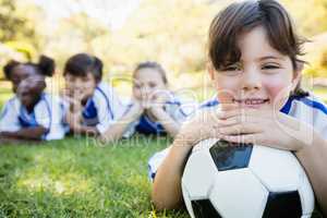 Close up view of girl lying on the floor with her soccer team
