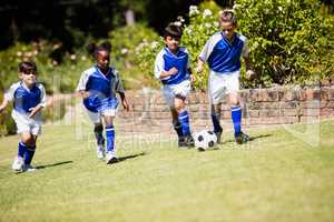 Children wearing soccer uniform playing a match