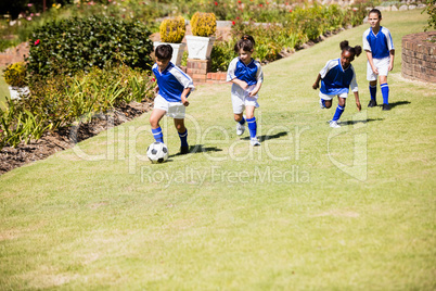 Children wearing soccer uniform playing a match