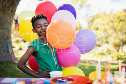 Cute boy smiling and posing next to balloon during a birthday pa