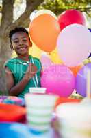 Cute boy smiling and posing next to balloon during a birthday pa
