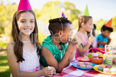 Close up of cute girl smiling in front of other children during
