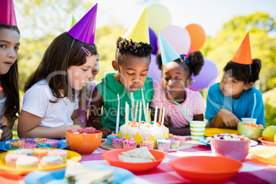 Cute children blowing together on the candle during a birthday p